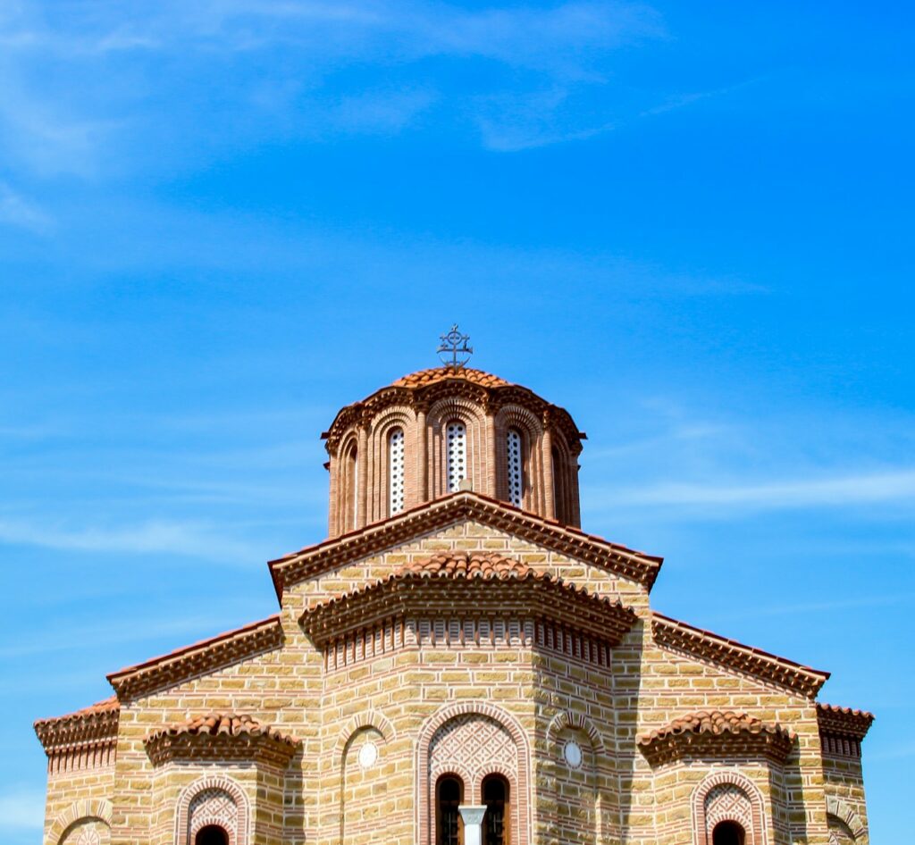 brown and white concrete church under blue sky